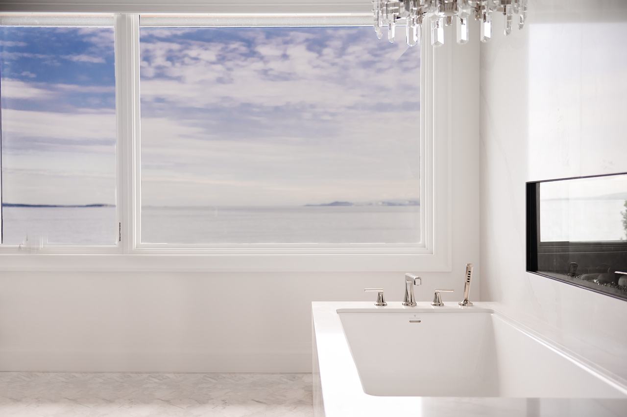 Ocean-view ensuite with a freestanding soaker tub and wall-mounted filler in Qualicum Beach