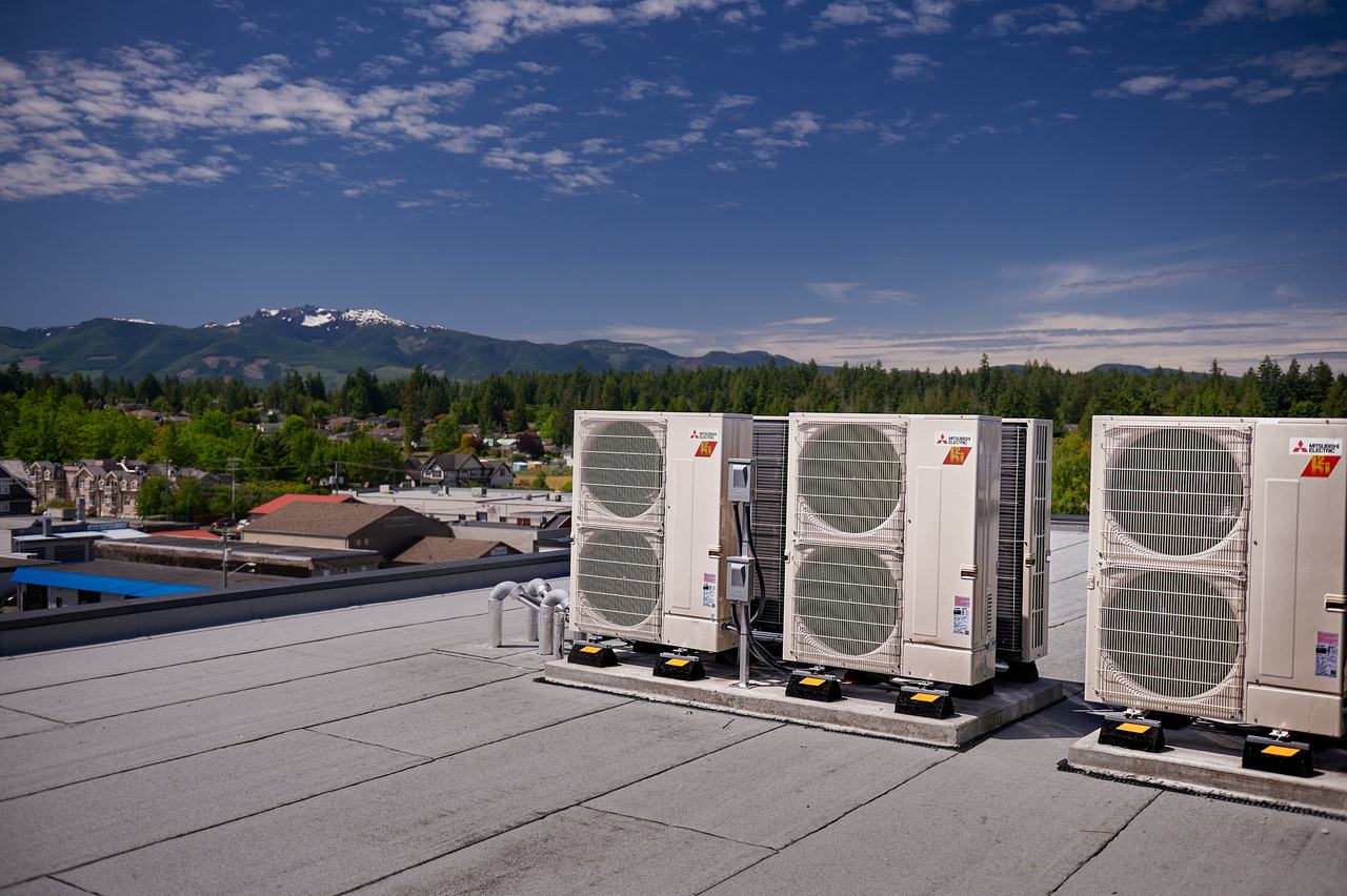 Rooftop heat pump condensers overlooking Qualicum Beach and the mountains