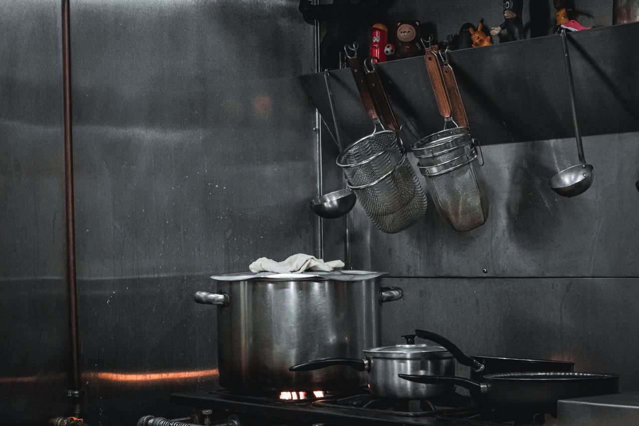 Stainless steel commercial kitchen with pots and utensils