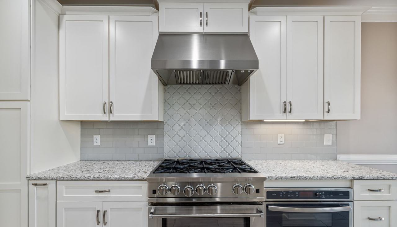 Stainless steel gas range and oven under a range hood