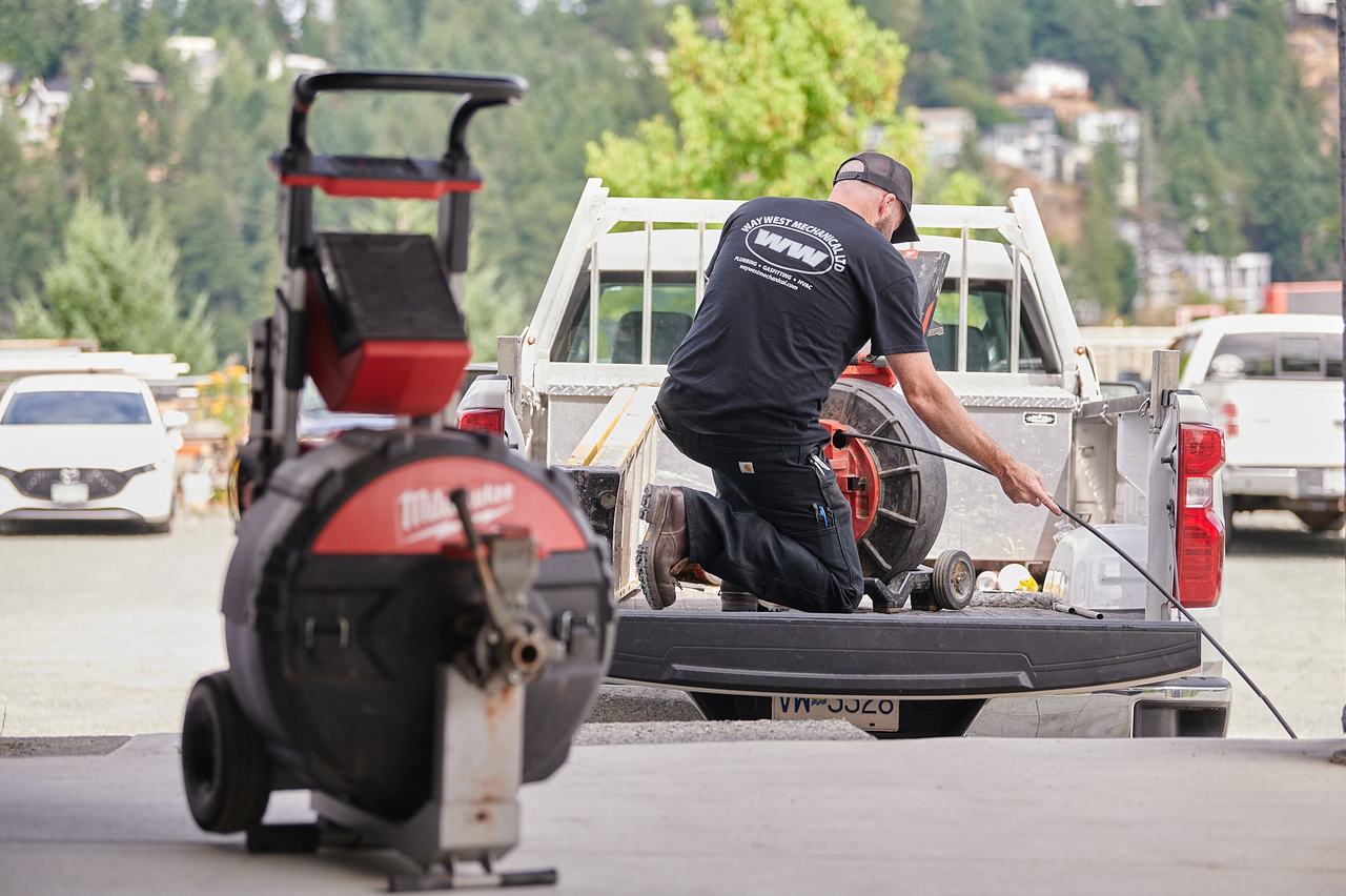 Waywest plumber loading a drain cleaning machine into a service truck in Nanaimo