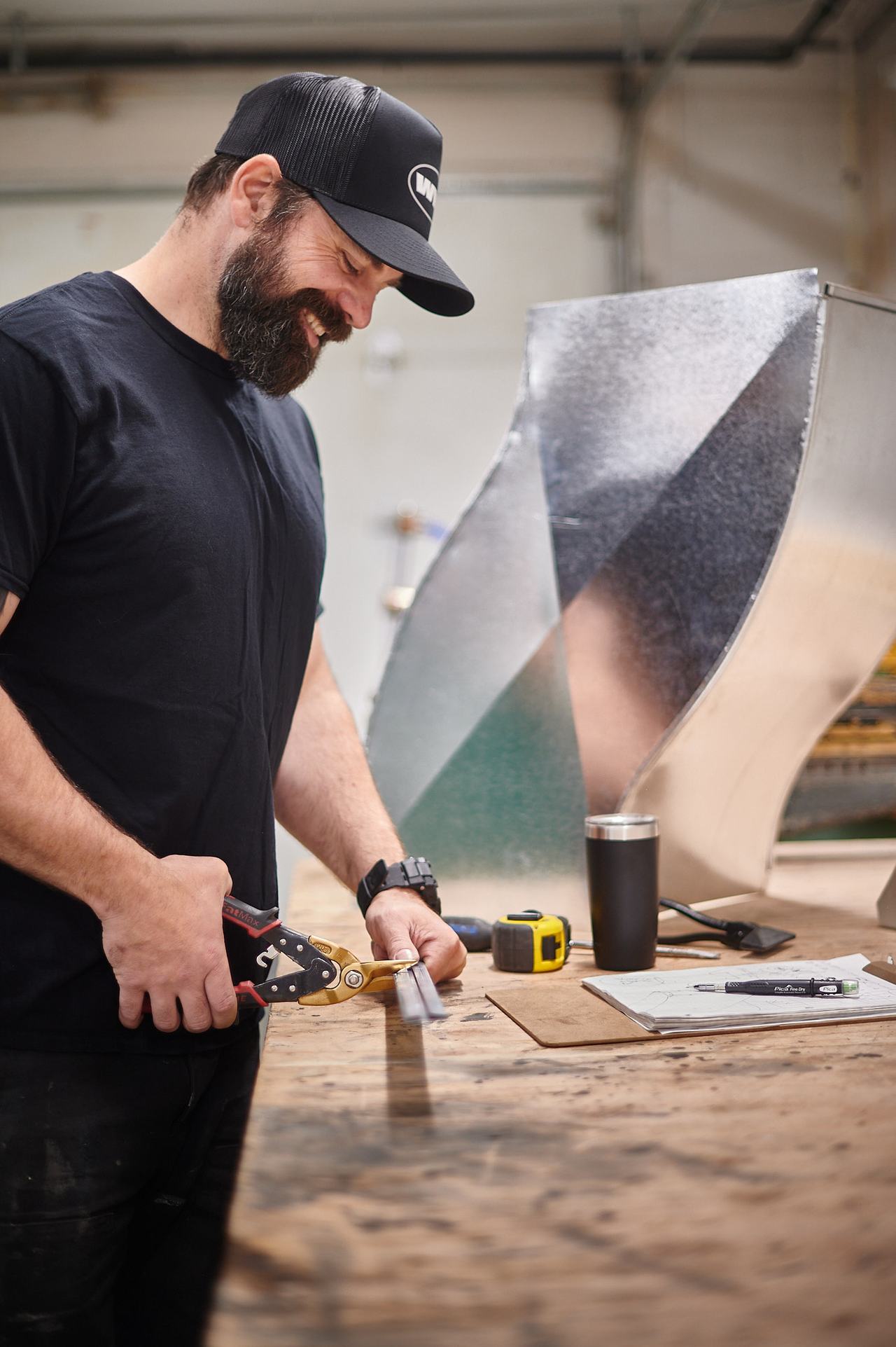 Waywest sheet metal worker cutting a custom duct fitting in the Nanaimo shop