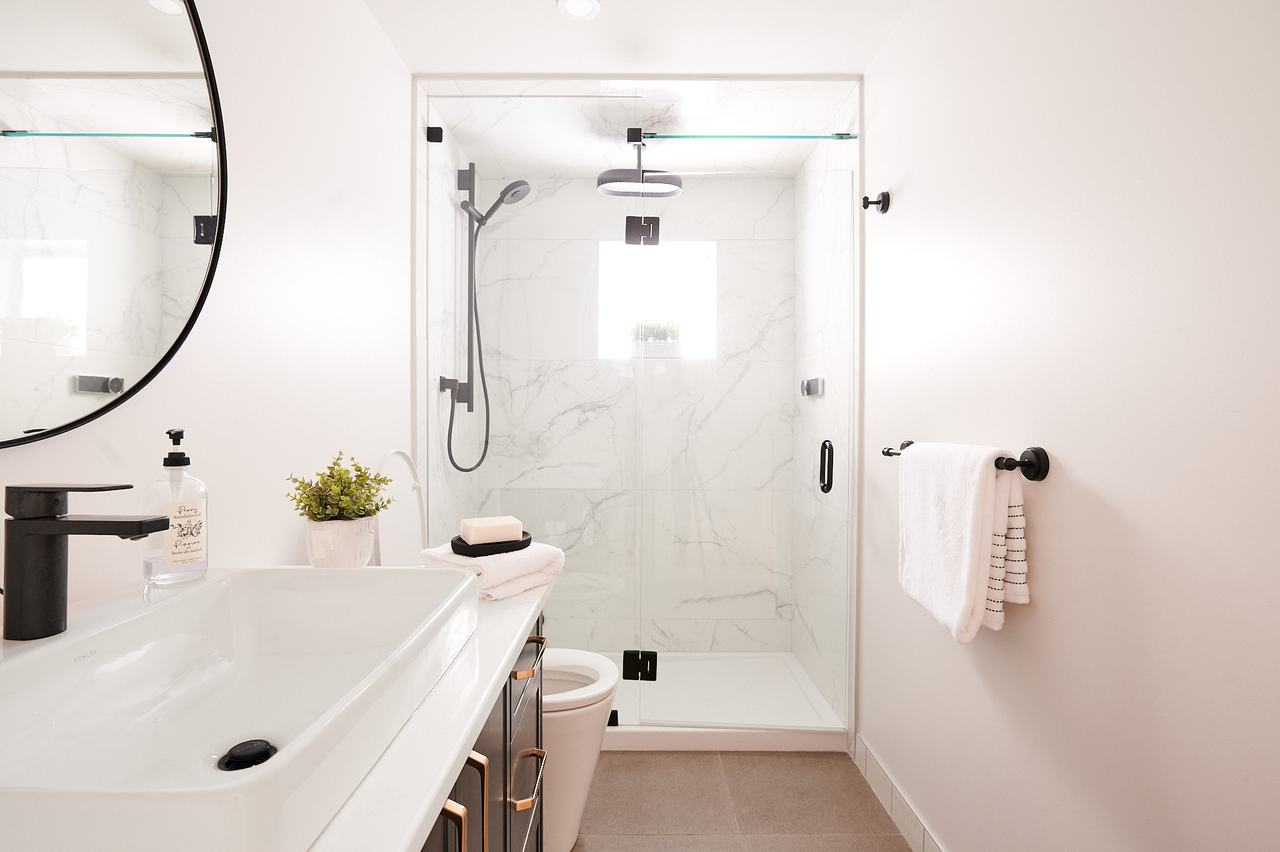 Renovated bathroom with glass walk-in shower and new vanity plumbed by Waywest